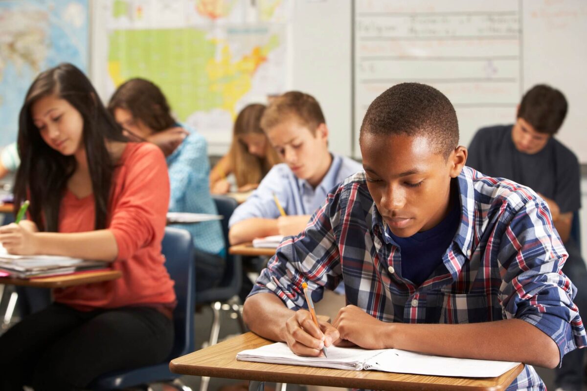 Diverse group of students in classroom writing notes